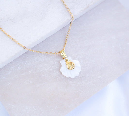 Gold Shell Mother of Pearl Necklace on stone displayed, made with mother of pearl pendants and a dainty tiny gold shell.