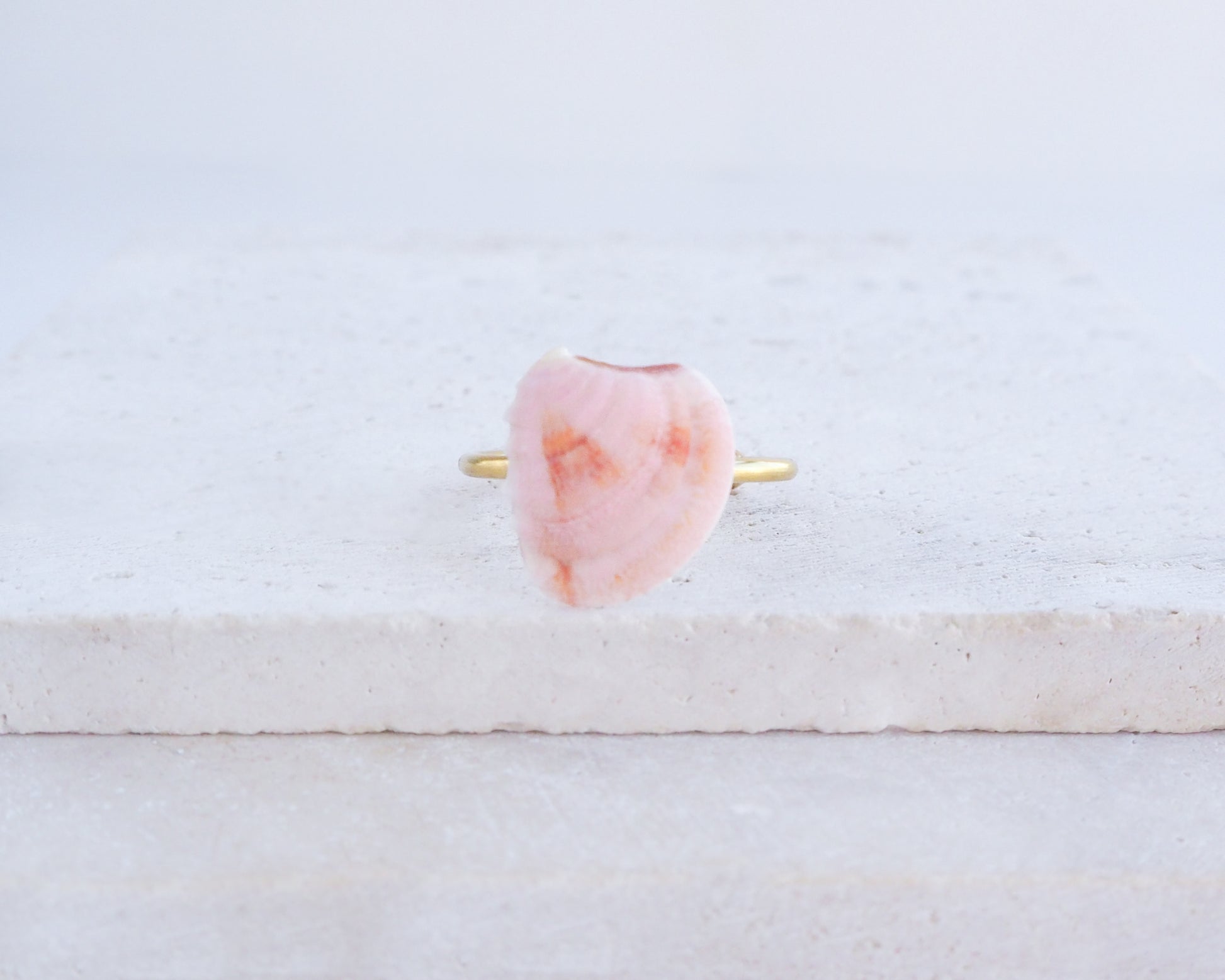 Soft Pink Orange Venus Shell Gold Ring on stone 