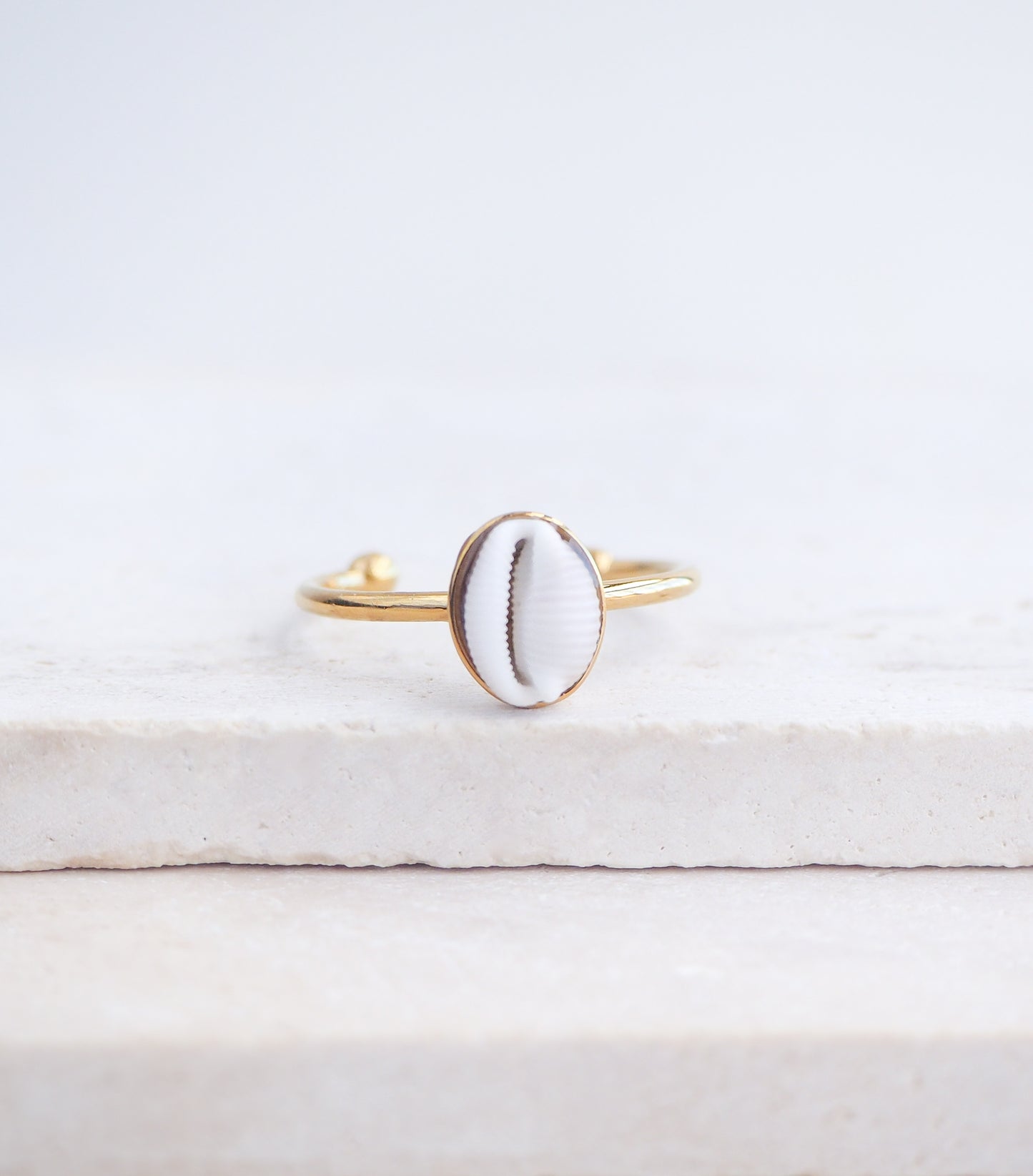 Close up front view of European Cowrie Shell Gold Ring Small from Portugal on stone display, Handpicked Spotted Cowrie Shell from Portugal, Gold Stainless Steel ring with tiny cowrie shell, Gift for beach girls