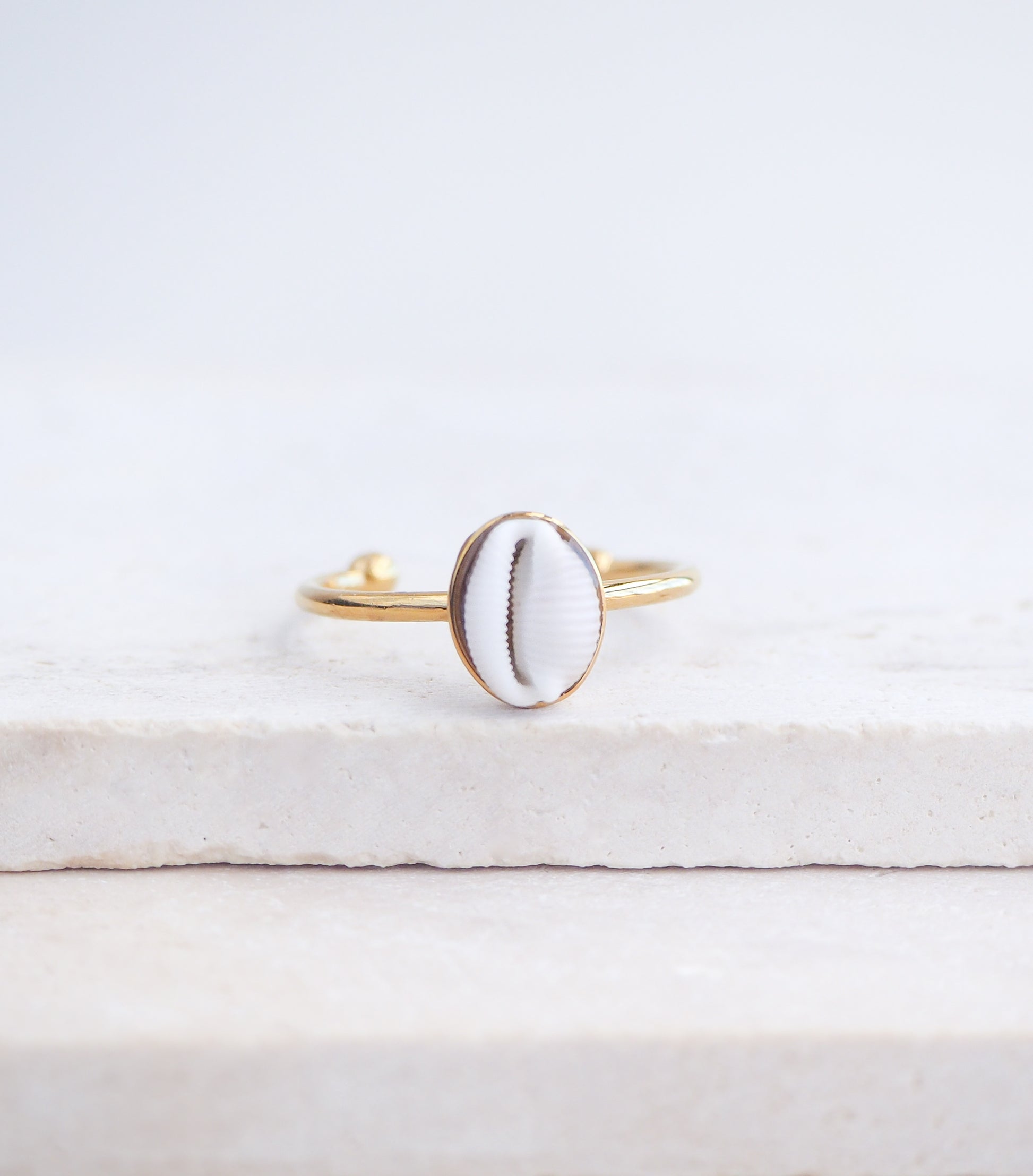 Close up front view of European Cowrie Shell Gold Ring Small from Portugal on stone display, Handpicked Spotted Cowrie Shell from Portugal, Gold Stainless Steel ring with tiny cowrie shell, Gift for beach girls