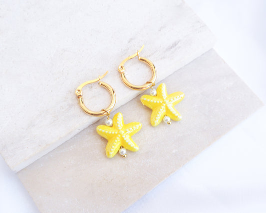 Gold Yellow Ceramic Starfish Sea Star Hoop Earrings on stone displayed