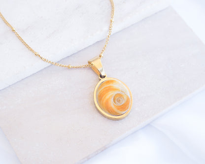 Gold Yellow Orange Shiva Eye, Eye of Saint Lucia Gold Necklace on stone displayed, 18k gold stainless steel shiva Yellow Orange eye pendant necklace, Saint Lucy Eye, operculum pendant
