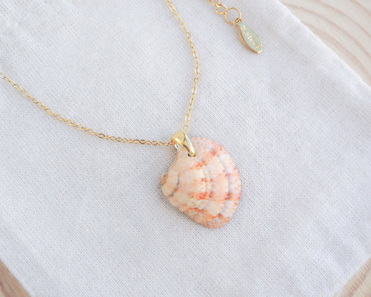 Side view of Orange Coral Venus Shell Necklace on display. Real natural venus shell handpicked from Portugal. Made with 18k gold stainless steel clasp and chain. 