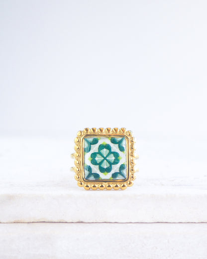 Green Gold Portuguese Tile Square Ring on stone displayed. Rings is handmade with 18k gold stainless steel and has a green floral tile pattern inspired by the Portuguese azulejos tiles. 