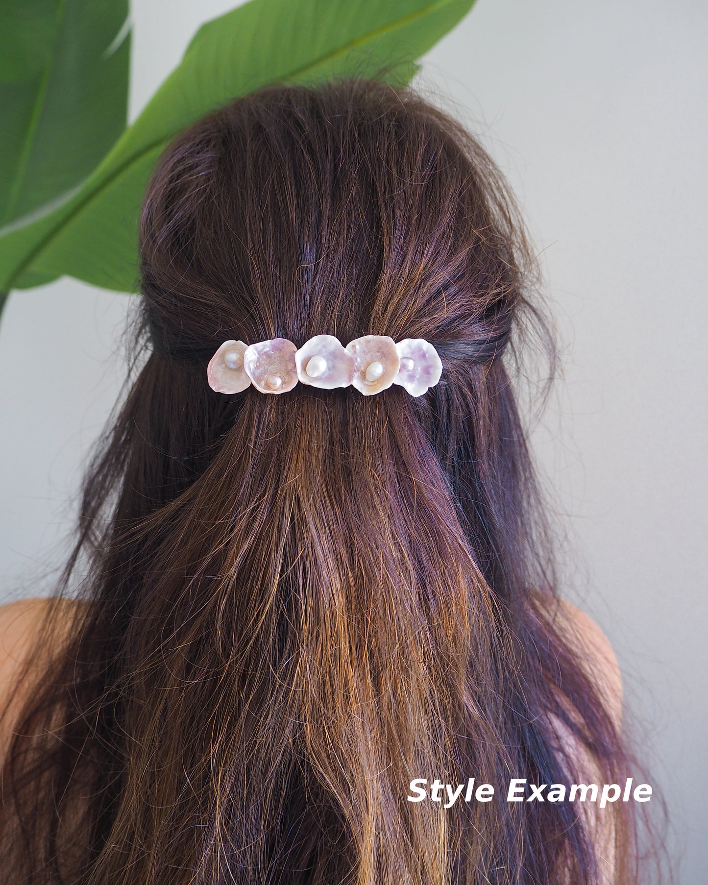 Model wearing a Jingle Shell Pearl Hair clip in brown hair with green plant background. Pearly shell Hair Clip Barrette made with pink fuchsia jingle shells from Portugal., Boho Seashell Beach Clip from Portugal, Handpicked Real Shells, Seashell Hair Decoration, Bohemian Seashell Wedding Hair Assocciares, Coastal Christmas gift, Beach Wedding Hair