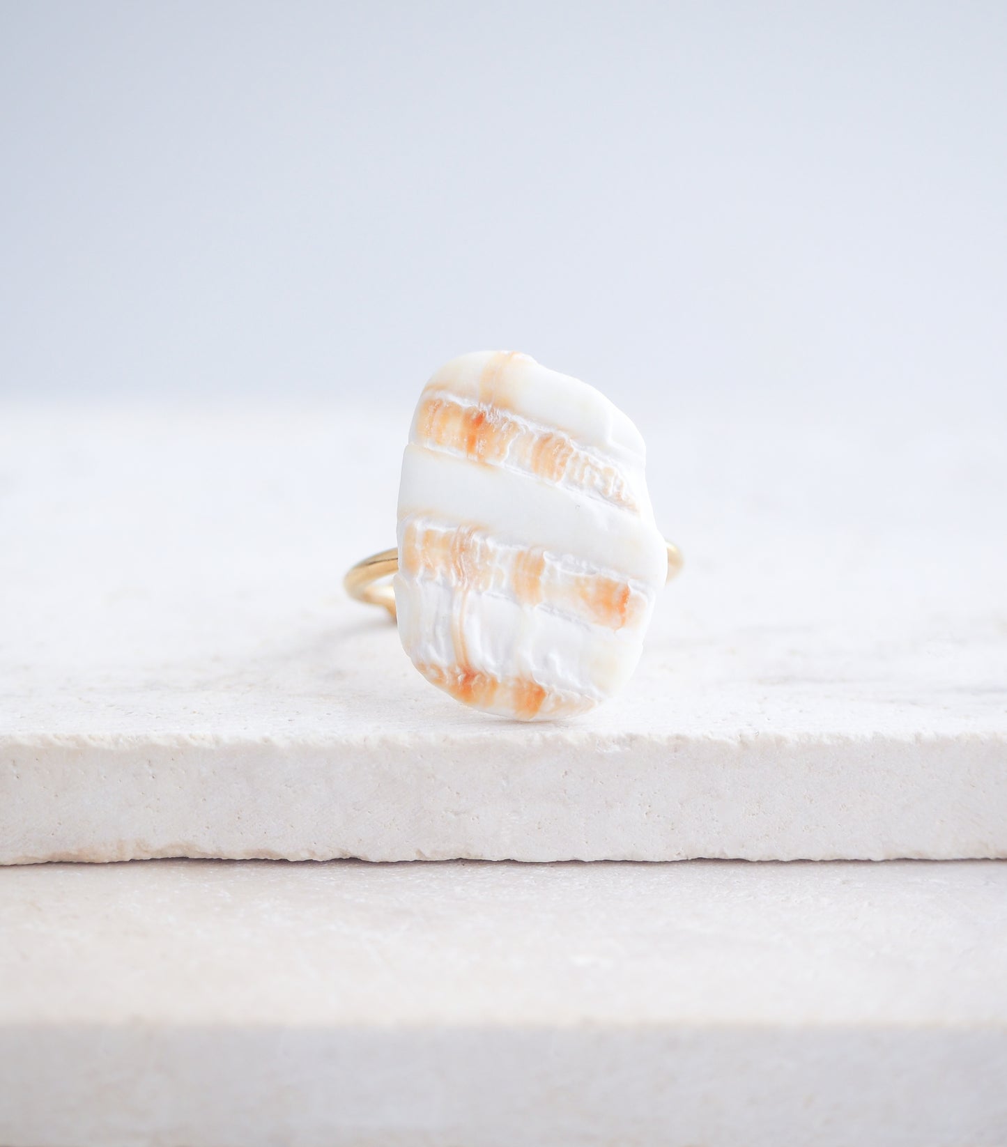 Mediterranean Cockle Shell Piece Gold Ring from Portugal on stone displayed, beach surf girl jewelry, gold ring with Portuguese cockle shell, ocean inspired beach jewelry, sunny yellow orange shell from Algarve