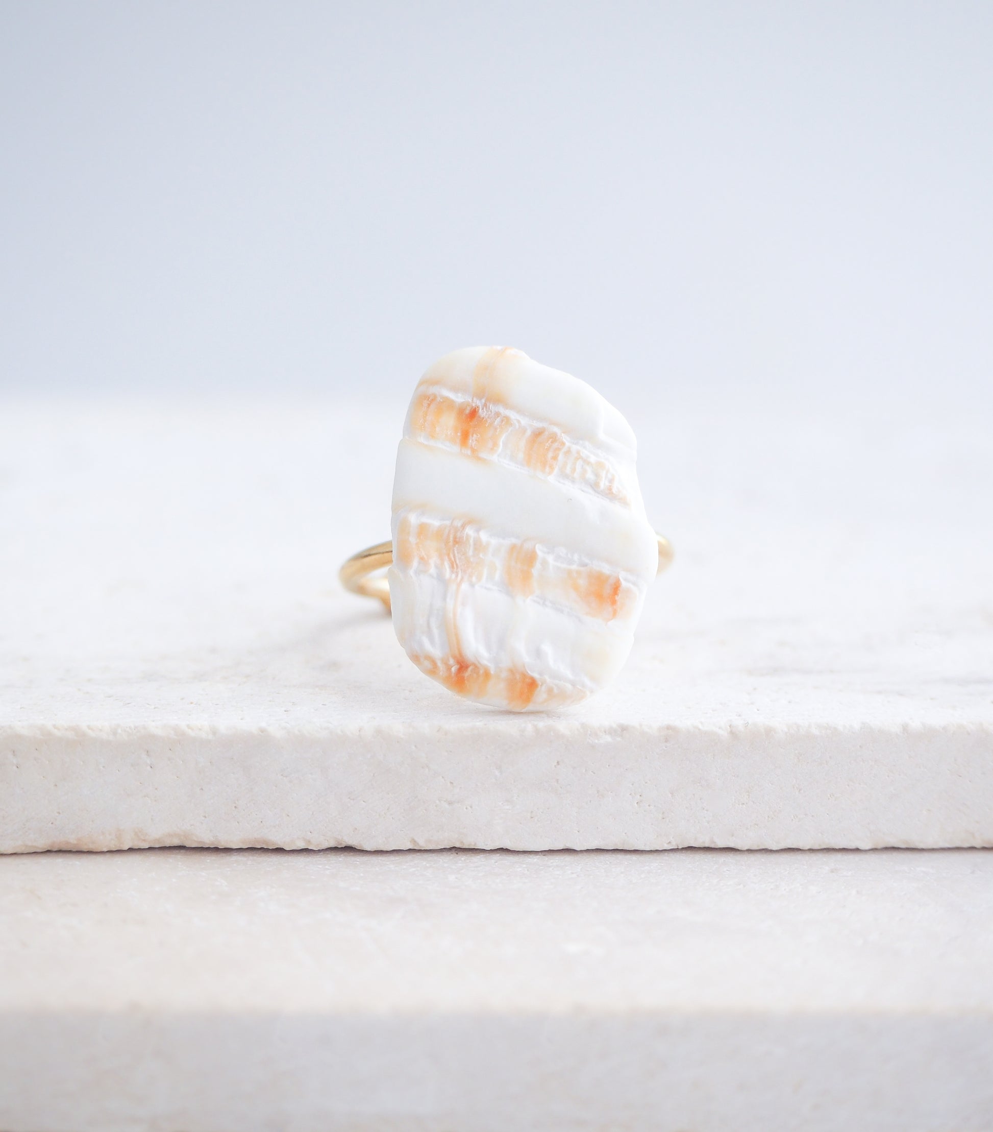 Mediterranean Cockle Shell Piece Gold Ring from Portugal on stone displayed, beach surf girl jewelry, gold ring with Portuguese cockle shell, ocean inspired beach jewelry, sunny yellow orange shell from Algarve