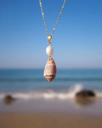 Mediterranean Cone Shell Pearl Necklace from Portugal front view with ocean background, handpicked cone shell from Algarve, Freshwater pearl and 18k gold stainless steel chain