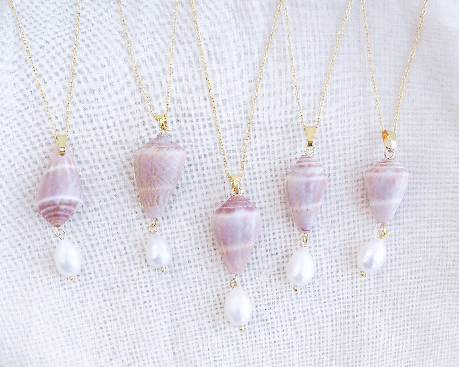 Mix of Mediterranean Cone Shell Pearl Necklaces Reversed from Portugal displayed, handpicked cone shell from Algarve, Freshwater pearl and 18k gold stainless steel chain