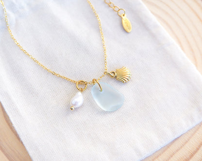 Display with Oceanic Trio Shell Light Blue Sea Glass Pearl Necklace, scallop shell necklace, ocean blue necklace, coastal jewelry, freshwater pearl necklace, gold seashell necklace, ocean-inspired jewelry, beach necklace, ocean treasure necklace