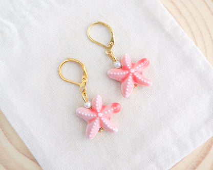 Pink Coral Starfish Ceramic Earrings on display