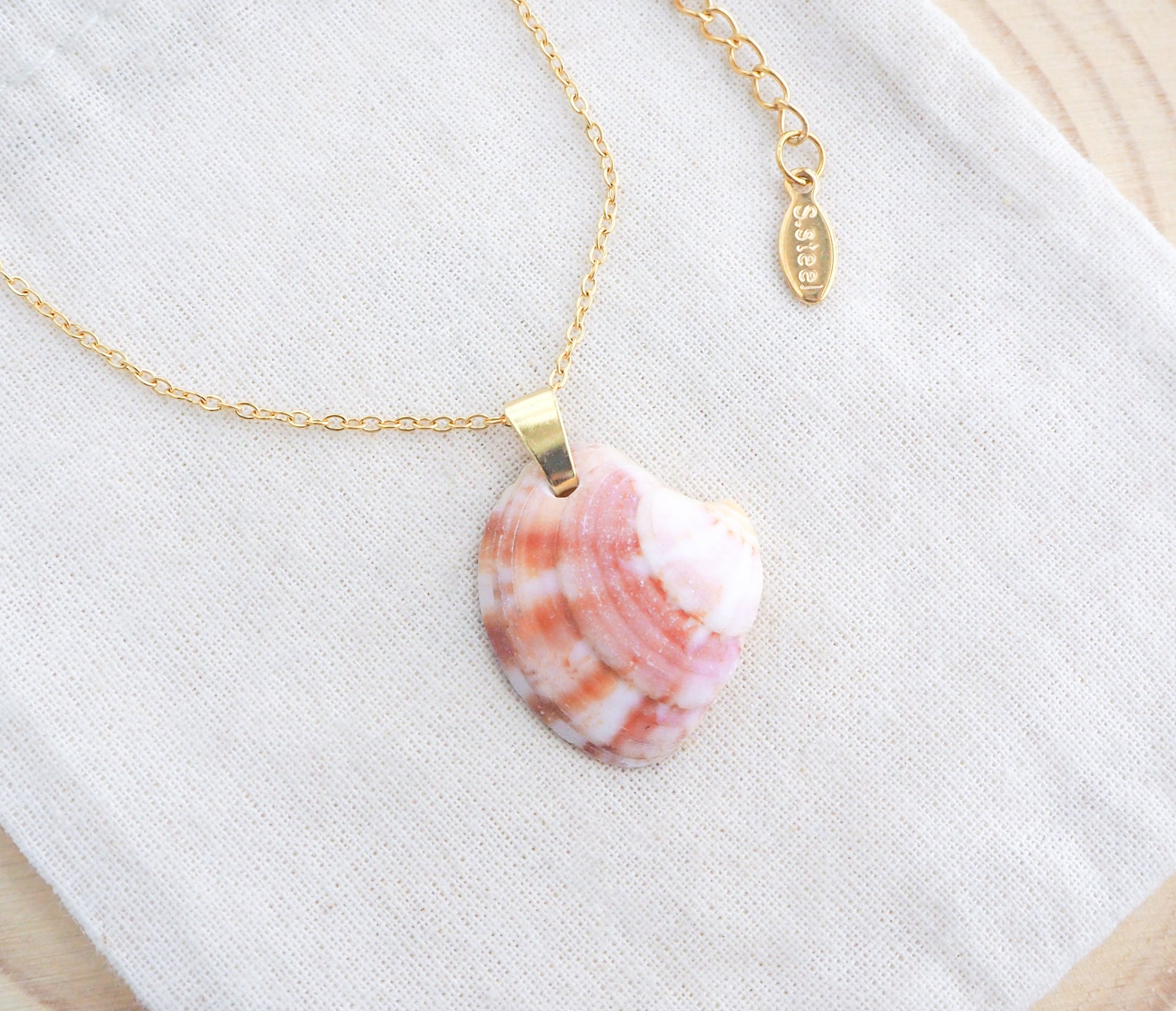 Pink Coral Venus Shell Gold Necklace on display