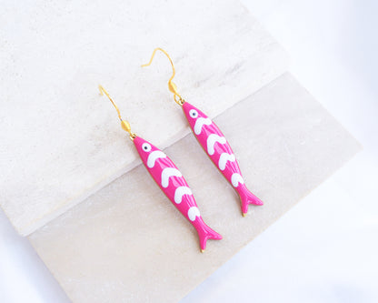 Pink Sardine Fish Earrings with 14k gold stainless steel earring hooks displayed on stone, Beautiful gift for Portugal lovers or holiday memory, coastal jewelry from Portugal