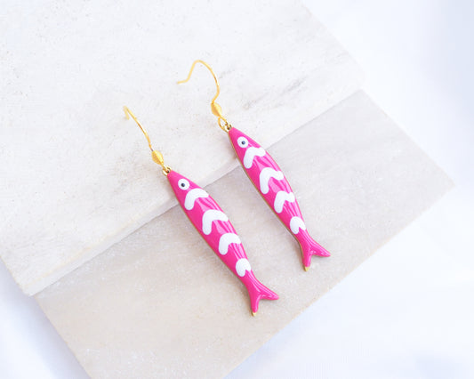 Pink Sardine Fish Earrings with 14k gold stainless steel earring hooks displayed on stone, Beautiful gift for Portugal lovers or holiday memory, coastal jewelry from Portugal