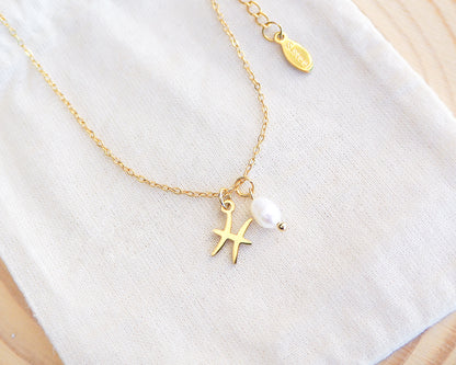 Close up of Gold Pisces Zodiac Pearl Necklace on display, made with 18k gold stainless steel and white freshwater pearl 
