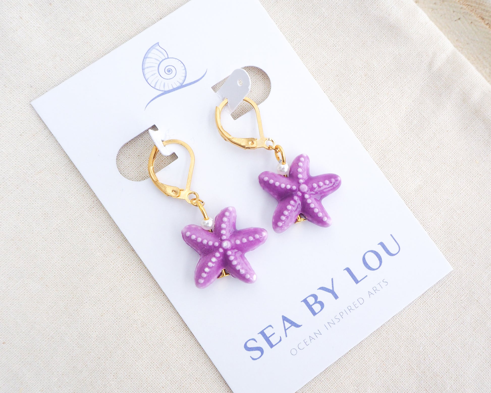 Purple Sea Star Ceramic Gold Earrings on display
