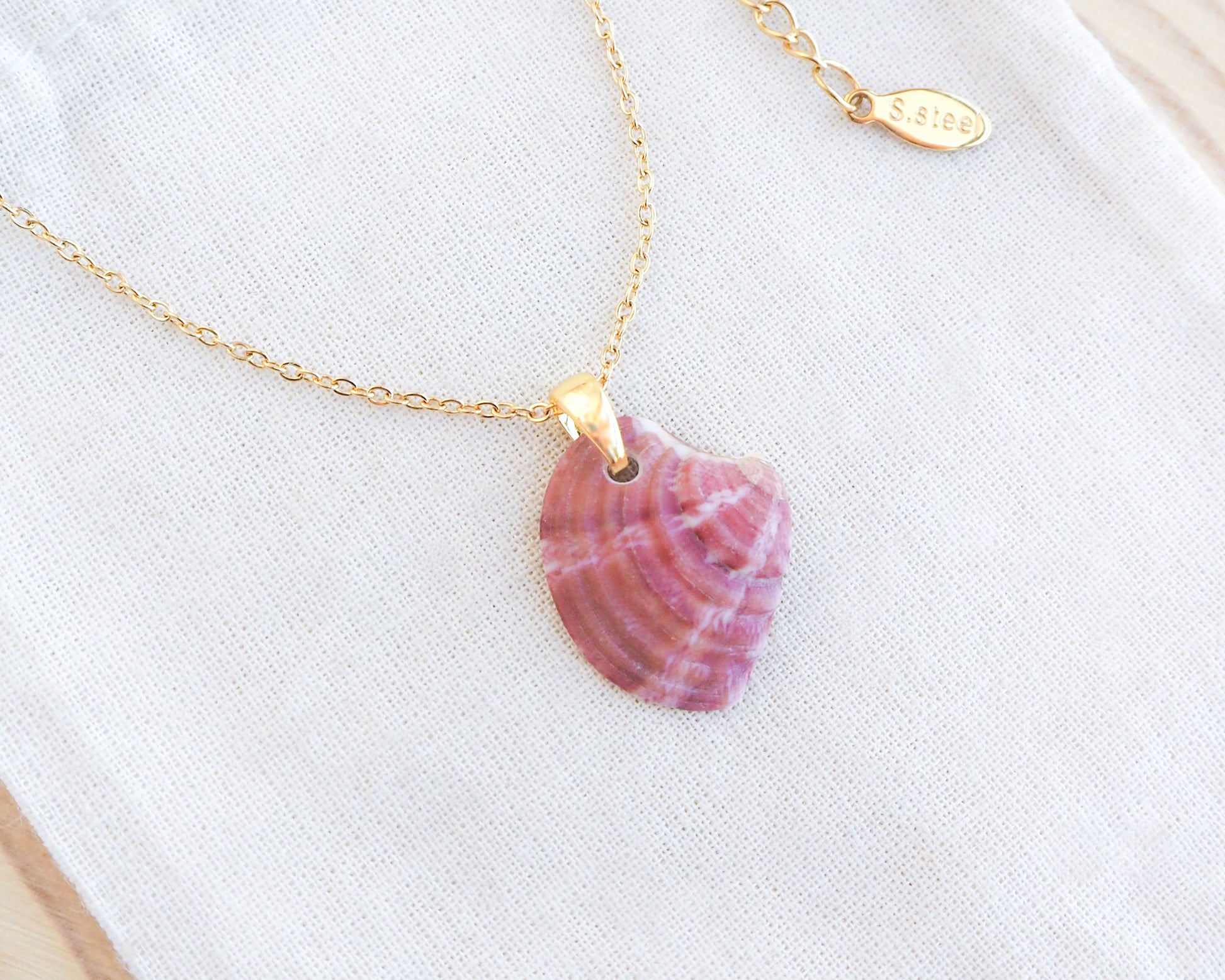 Raspberry Fuchsia Venus Shell Gold Necklace on display 