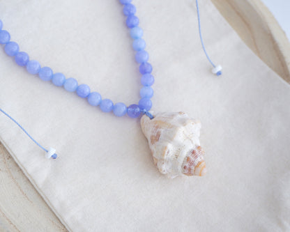 Red-mouthed Dog Winkle Shell with Angelite Gemstone Necklace on display, Blue gemstone bead necklace with off white big conch shell