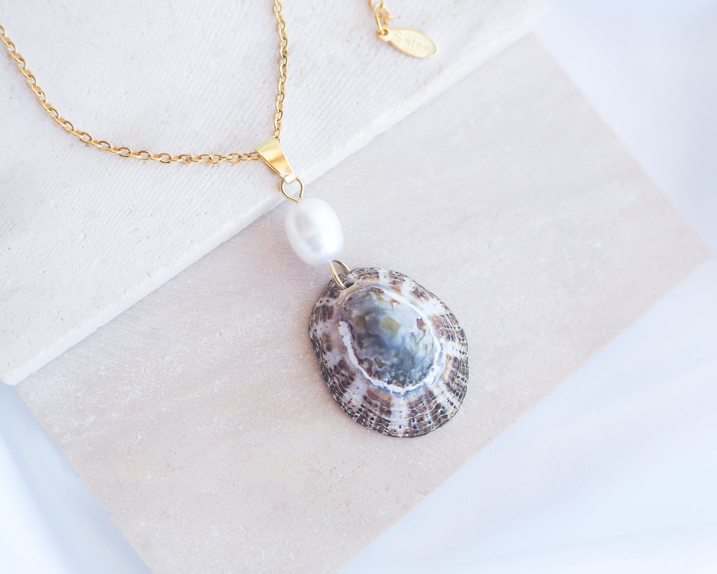 Front view of Rustic Limpet Shell Pearl Necklace on display, Blue White Striped Limpet Shell from Portugal with freshwater pearl and gold chain. 