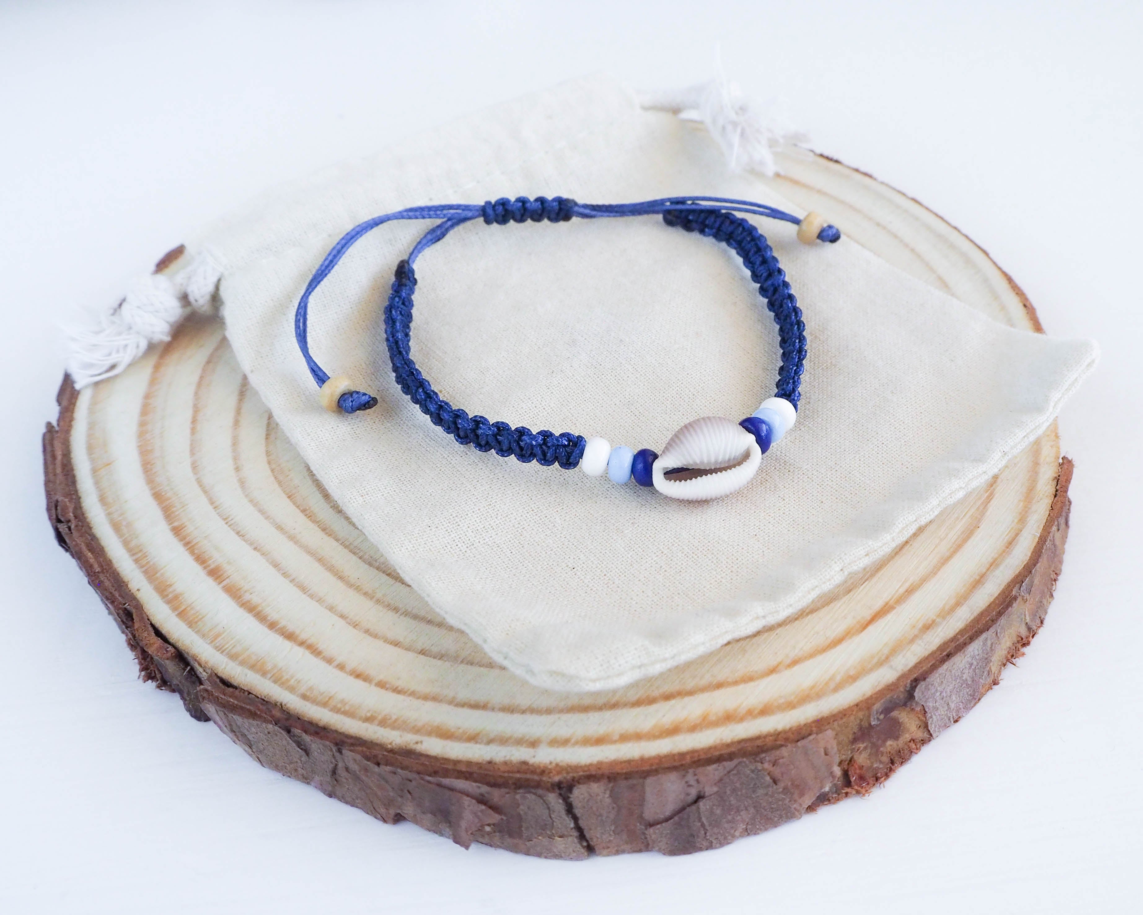 Premium Photo | Beaded bracelet with seashell charm resting on a limestone  rock