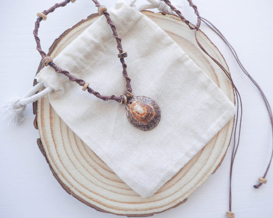 An image showcasing the adjustable feature of the necklace. The clasp is visible, allowing the length of the braided brown wax cord to be customized to suit different necklines and preferences.