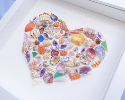 Collection of colorful seashells arranged in a circular pattern on a white surface. Side view of Rainbow Seashell Heart Artwork with colorful shell handpicked from Portugal. Coastal Home Wall Decor, Shell Wall Art, Handmade Shell Artwork, Cute Coastal Nursery Decoration 
