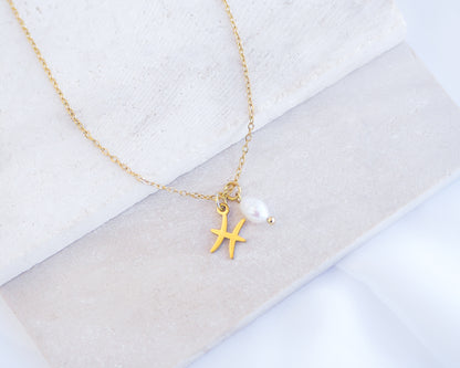 Gold Pisces Zodiac Pearl Necklace on stone displayed, made with 18k gold stainless steel and white freshwater pearl 