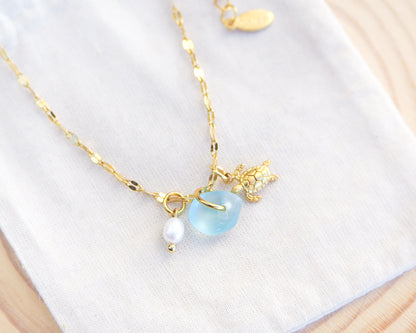 Close up of Tiny Turtle Blue Sea Glass Pearl Necklace II on cotton displayed, tiny turtle necklace, ocean blue necklace, coastal jewelry, freshwater pearl necklace, gold turtle necklace 