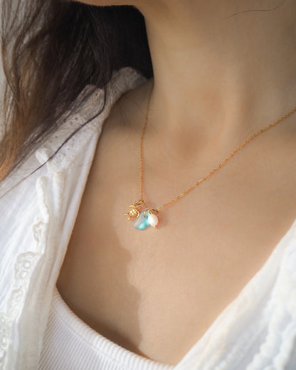 Model wearing Tiny Sea Turtle Blue Sea Glass Pearl Necklace on stone displayed, tiny turtle necklace, turquoise blue necklace, coastal jewelry, freshwater pearl necklace, gold turtle necklace 