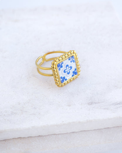 Side view of Blue Gold Portuguese Tile Square Ring on stone displayed. Rings is handmade with 18k gold stainless steel and has a blue white floral tile pattern inspired by the Portuguese azulejos tiles. 