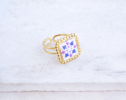 Side view of Purple Gold Portuguese Tile Square Ring on stone displayed. Rings is handmade with 18k gold stainless steel and has a purple pink tile pattern inspired by the Portuguese azulejos tiles. 