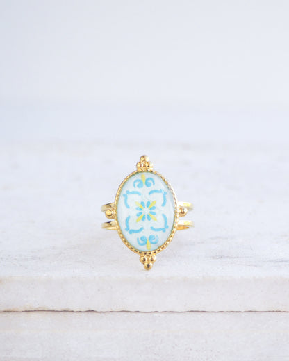 Blue Turquoise Portuguese Tile Oval Deluxe Rings on stone displayed. The ring is handmade with 18k gold stainless steel and are made with different patterns inspired by the Portuguese azulejos tiles. 