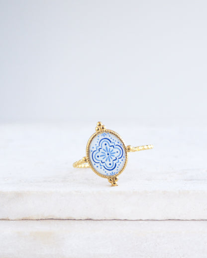 Blue White Portuguese Tile Oval Rings on stone displayed. The ring is handmade with 18k gold stainless steel and are made with different patterns inspired by the Portuguese azulejos tiles. 