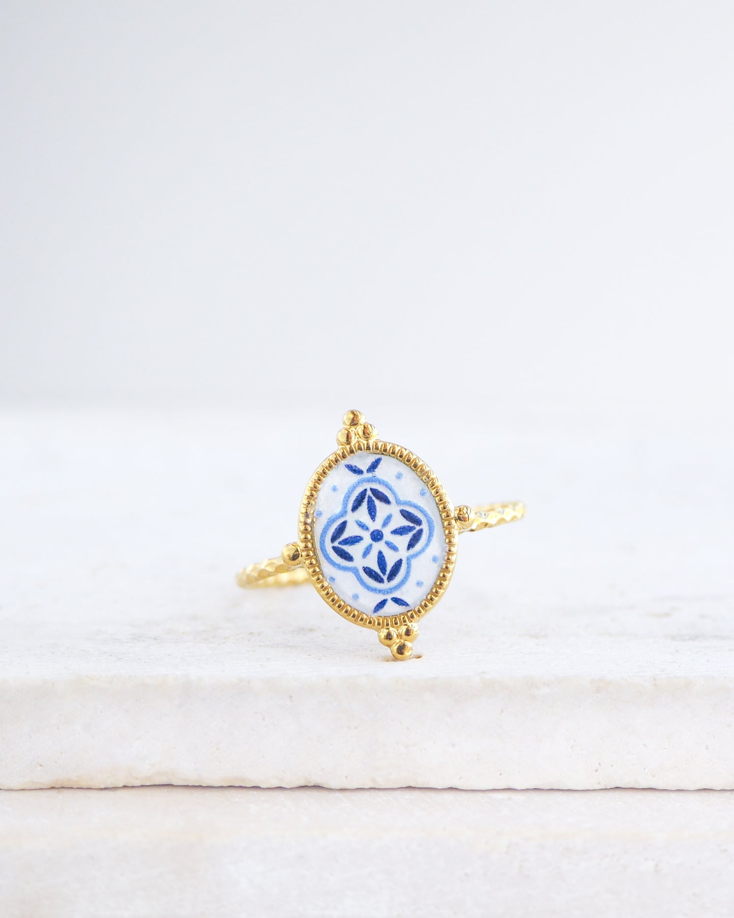 Blue Portuguese Tile Oval Rings on stone displayed. The ring is handmade with 18k gold stainless steel and are made with different patterns inspired by the Portuguese azulejos tiles. 