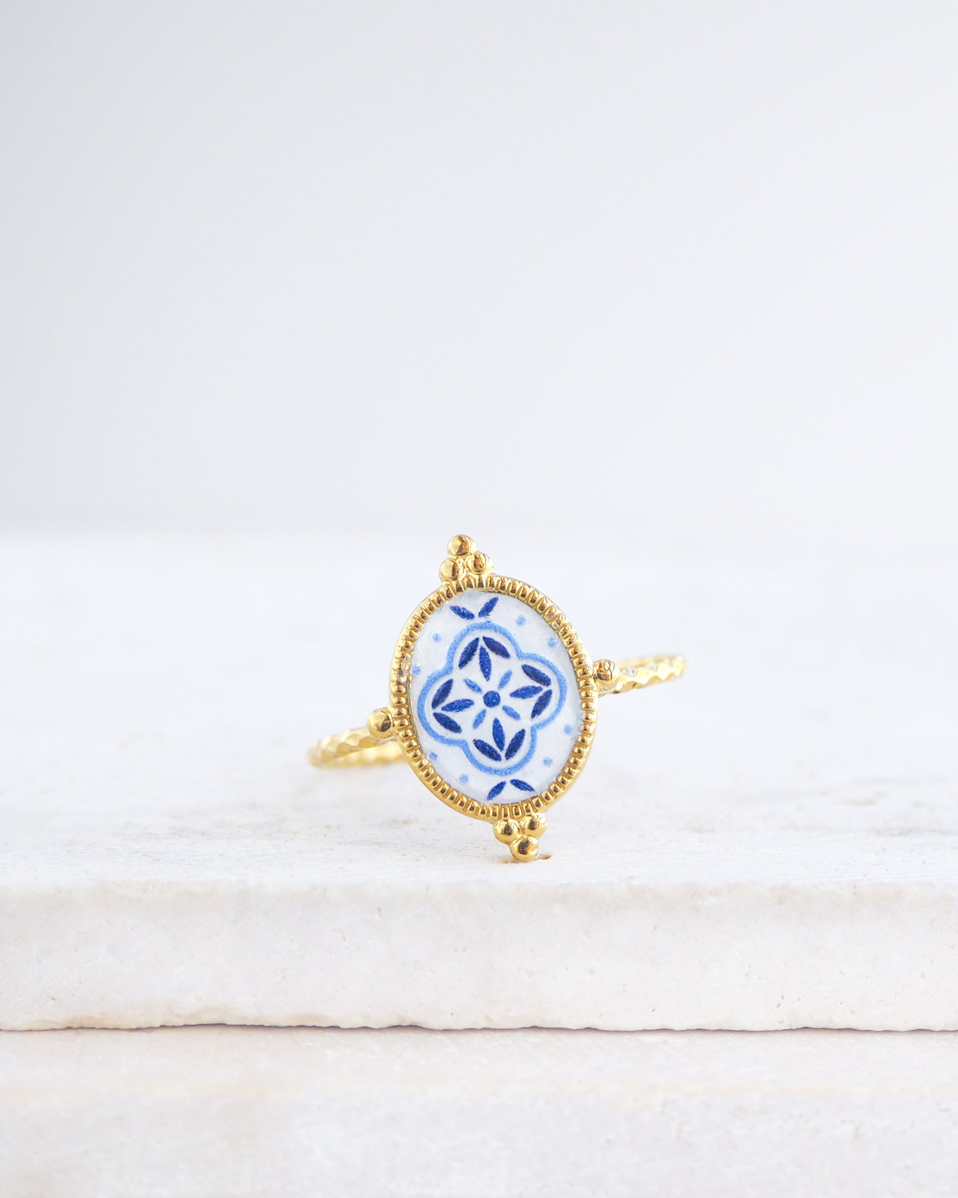 Blue Portuguese Tile Oval Rings on stone displayed. The ring is handmade with 18k gold stainless steel and are made with different patterns inspired by the Portuguese azulejos tiles. 