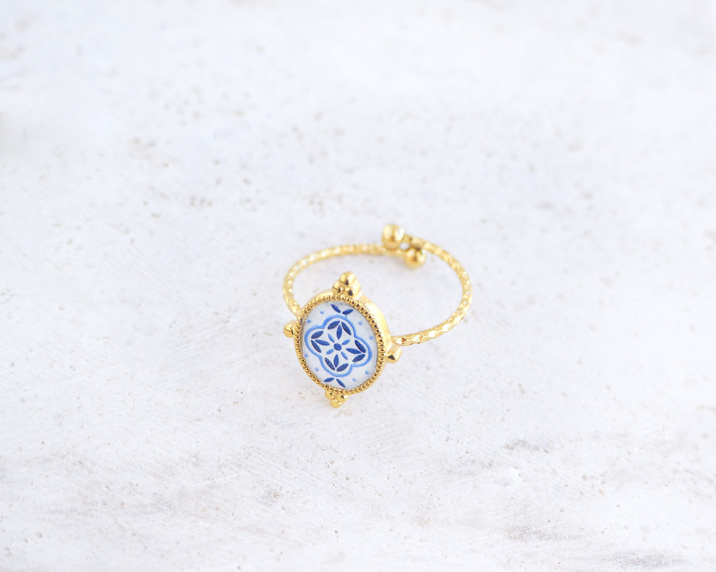 Side view of Blue Portuguese Tile Oval Rings on stone displayed. The ring is handmade with 18k gold stainless steel and are made with different patterns inspired by the Portuguese azulejos tiles. 