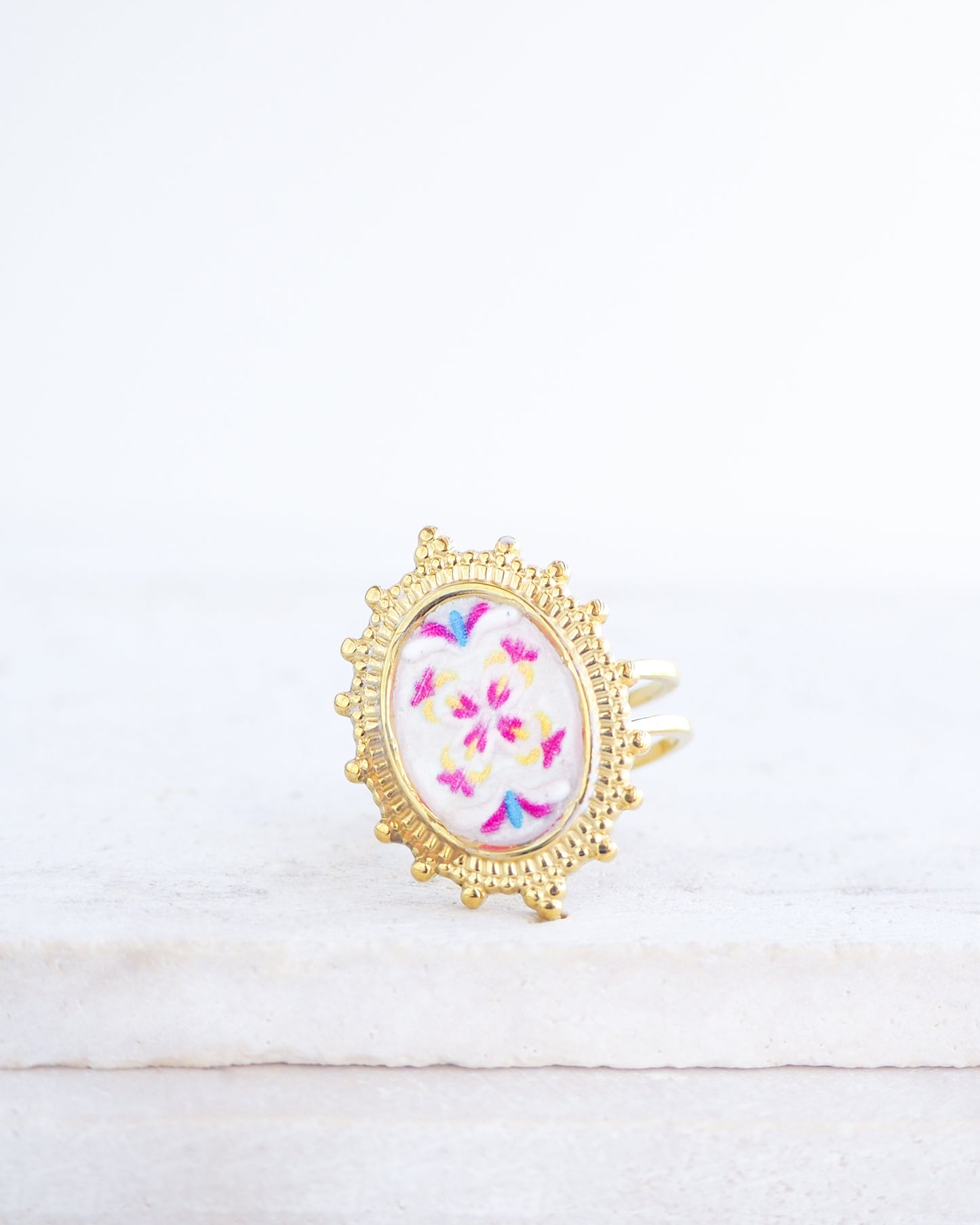 Front view of Fuchsia Portuguese Tile Oval Deluxe Rings on stone displayed. The ring is handmade with 18k gold stainless steel and are made with different patterns inspired by the Portuguese azulejos tiles. 