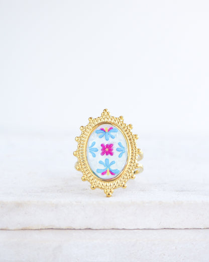 Front view of Blue Fuchsia Portuguese Tile Oval Deluxe Rings on stone displayed. The ring is handmade with 18k gold stainless steel and are made with different patterns inspired by the Portuguese azulejos tiles. 