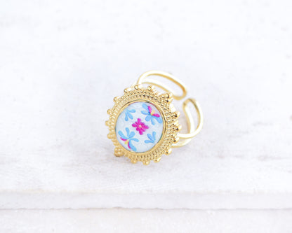 side view of Blue Fuchsia Portuguese Tile Oval Deluxe Rings on stone displayed. The ring is handmade with 18k gold stainless steel and are made with different patterns inspired by the Portuguese azulejos tiles. 