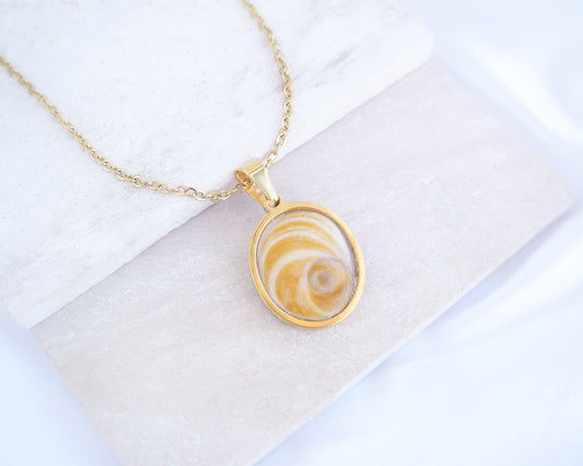 Gold Yellow Orange Shiva Eye, Eye of Saint Lucia Gold Necklace on stone displayed, 18k gold stainless steel shiva Yellow Orange eye pendant necklace, Saint Lucy Eye, operculum pendant