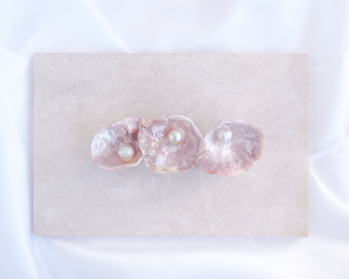 Medium Pearl oyster shell hair clip with pearls on a stone background. Made with handpicked jingle shells saddle oysters from Portugal. Jingle Shell Pearl Hair clip. pearly shell Hair Clip Barrette on stone displayed, Boho Seashell Beach Clip from Portugal, Handpicked Real Shells, Seashell Hair Decoration, Bohemian Seashell Wedding Hair accessories, Coastal Christmas gift, Beach Wedding Hair