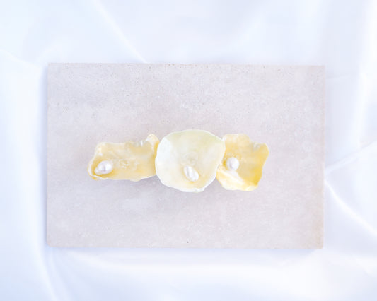 Pearl oyster shell hair clip with pearls on a stone background. Made with handpicked jingle shells saddle oysters from Portugal. The hair clips has 3 shells with a soft yellow color. Jingle Shell Pearl Hair clip. pearly shell Hair Clip Barrette on stone displayed, Boho Seashell Beach Clip from Portugal, Handpicked Real Shells, Seashell Hair Decoration, Bohemian Seashell Wedding Hair accessories, Coastal Christmas gift, Beach Wedding Hair
