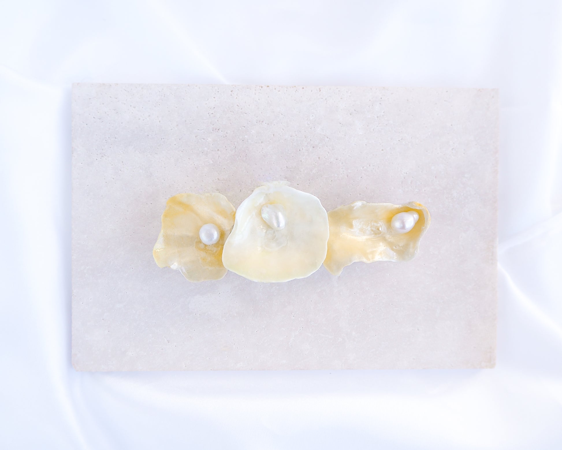 Close up of pearl oyster shell hair clip on stone displayed. Made with handpicked jingle shells saddle oysters from Portugal. The hair clips has 3 shells with a soft yellow color. Jingle Shell Pearl Hair clip. Boho Seashell Beach Clip from Portugal, Handpicked Real Shells, Seashell Hair Decoration, Bohemian Seashell Wedding Hair accessories, Coastal Christmas gift, Beach Wedding Hair