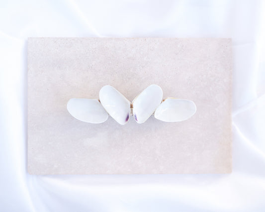 Butterfly-shaped hair clip on a beige stone background. White Coquina Shells Butterfly Hair Clip Barrette on light stone displayed. Handpicked Real Coquina Shells. The shells are white in color and attached on the hair clip like a butterfly. The model has brown long hair. Sea Butterfly Shell Hair Decoration, Seashell Wedding Hair accessories, Coastal Christmas gift, Beach Wedding Hair