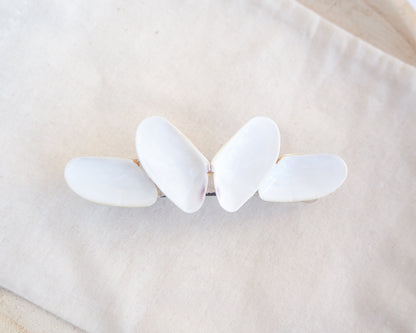White butterfly-shaped hair clip on a beige fabric background. Handpicked Real Coquina Shells. The shells are white in color and attached on the hair clip like a butterfly. The model has brown long hair. Sea Butterfly Shell Hair Decoration, Seashell Wedding Hair accessories, Coastal Christmas gift, Beach Wedding Hair