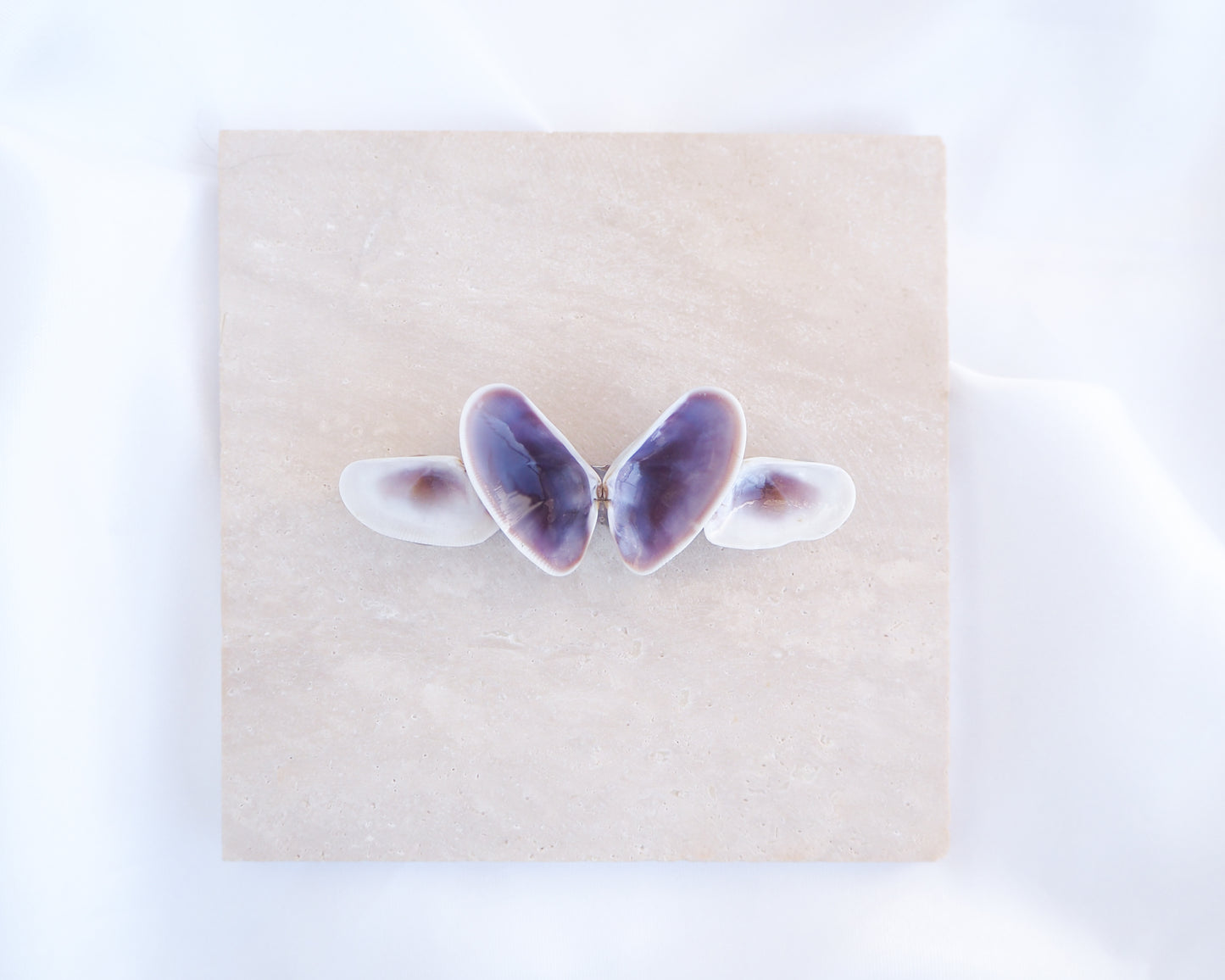 Butterfly-shaped hair clip on a beige square background. Made with purple white colored coquina shells set on a metal hair clip like a butterfly. Handpicked coquina shells from Portugal, Handpicked Real Coquina Shells, Sea Butterfly Shell Hair Decoration, Seashell Wedding Hair accessories, Coastal Christmas gift, Beach Wedding Hair
