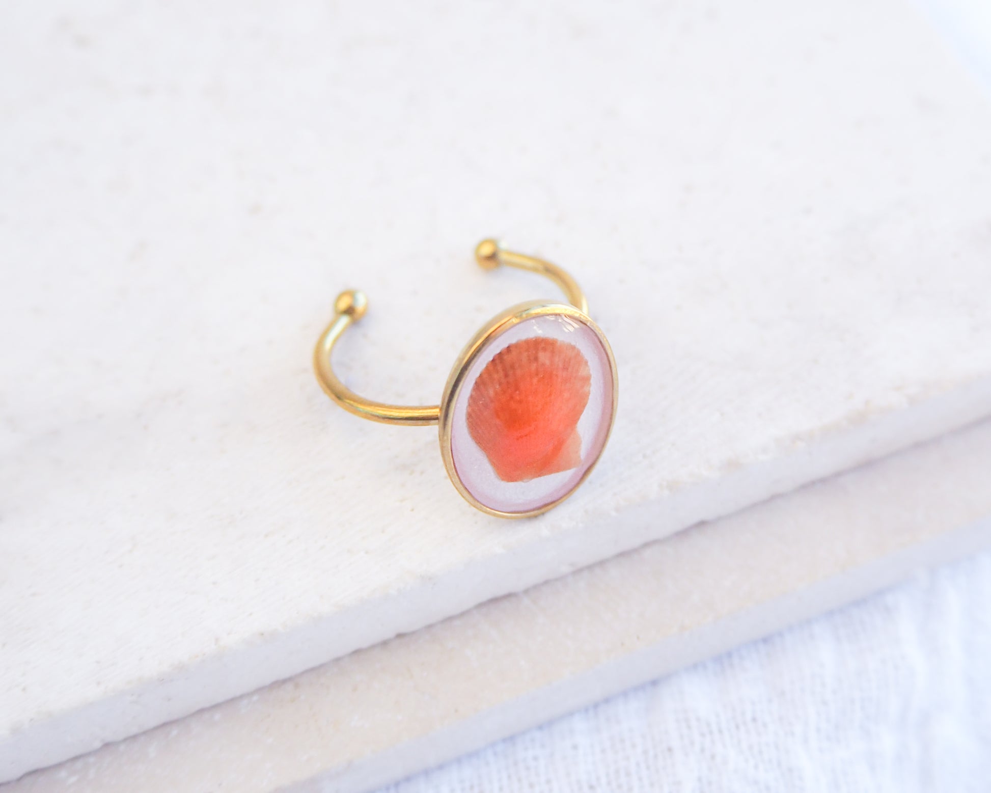 Tiny Orange Scallop Shell Gold Ring on stone displayed. Tiny Orange Scallop Shell Bezel Ring, 18k gold stainless steel, handpicked scallop shell from the beach of Portugal, variegated scallop shell  