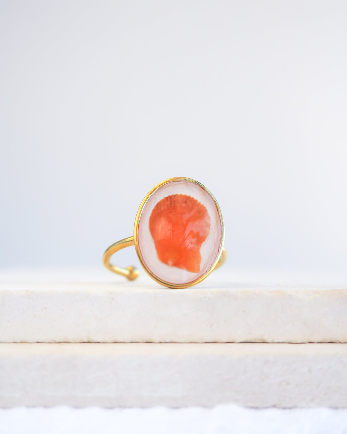 Close up of Tiny Orange Scallop Shell Gold Ring on stone displayed. Tiny Orange Scallop Shell Bezel Ring, 18k gold stainless steel, handpicked scallop shell from the beach of Portugal, variegated scallop shell  