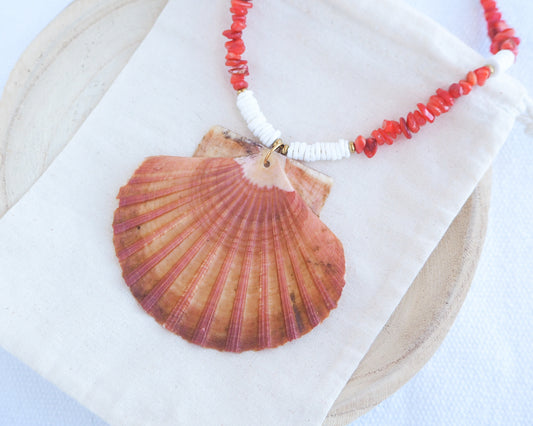 Necklace with a large shell pendant and red beads. a a big scallop shell paired with red stone beads and white shell beads. The shell is a great scallop shell from Portugal and is about 8 cm. The color of the shell is orange pink and it has vertical ridges. 
