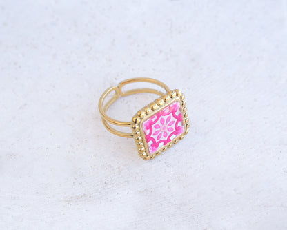 Side view of Pink Portuguese Tile Square Ring on stone displayed. Rings is handmade with 18k gold stainless steel and has a pink white floral tile pattern inspired by the Portuguese azulejos tiles. 